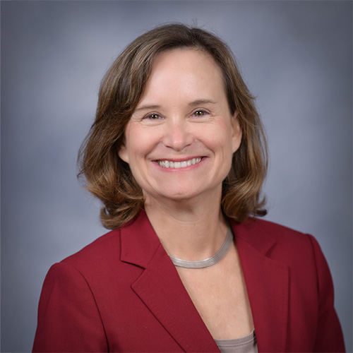 Portrait of Caroline Freund in red blazer