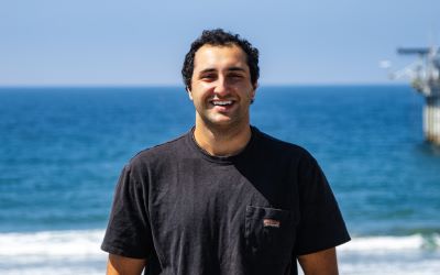 Dylan Shafer smiling in front of an ocean backdrop