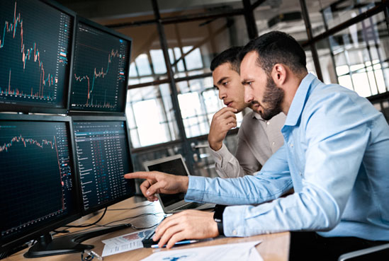 Men looking at graph on computer monitor